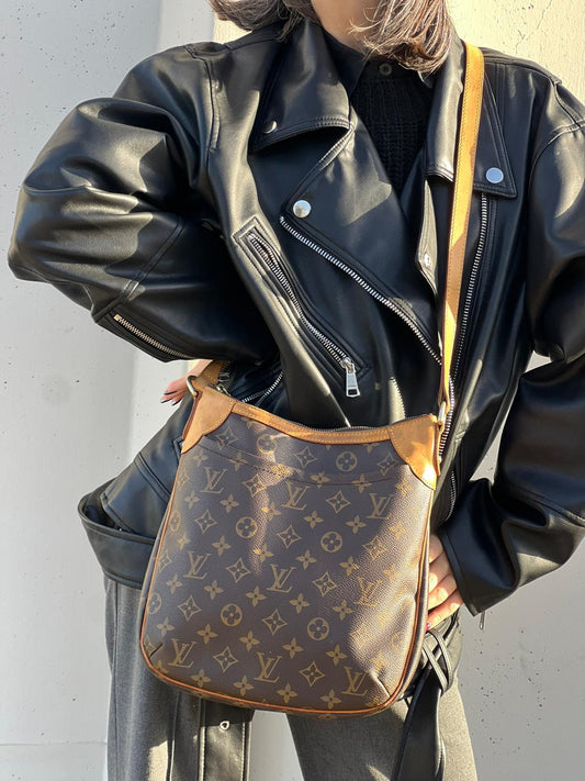 indossata Borsa Odeon PM Louis Vuitton in canvas marrone monogram con finiture in vacchetta naturale e parti metalliche dorate. Dotata di tracolla regolabile con fibbia, di lusso, originale, buone condizioni, usata.