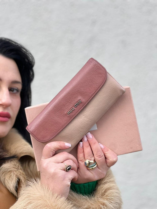 Portafoglio Miu Miu in pelle sulle tonalità del rosa e parti metalliche argentate. Munito di scatola, di lusso, usato, originale, ottime condizioni.