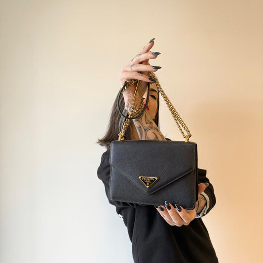 indossata Borsa Prada in pelle saffiano nera con parti metalliche dorate; munita di una tracolla in catena scorrevole con spallaccio in pelle. Full set, di lusso, originale, ottime condizioni.