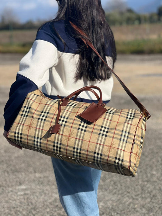 indossata Borsone Burberry in canvas trama tartan con finiture in pelle marroni e parti metalliche dorate; munito di doppi manici stondati e una tracolla amovibile. Completo di lucchetto e chiavi, di lusso, originale, ottime condizioni.