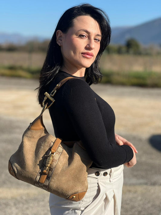 indossata della Borsa Gucci scamosciata beige con finiture in pelle color cammello, dettagli in tessuto GG e parti metalliche dorate; munita di un manico singolo, indossabile a spalla. Completa di dustbag, di lusso, originale, ottime condizioni, usata.