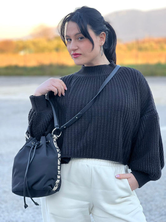 Ragazza che indossa un Secchiello Stella McCartney in tessuto nero con banda laterale jacquard con logo a contrasto e parti metalliche argentate. Dotato di chiusura a coulisse, manico singolo e tracolla in pelle amovibile. Completo di dustbag. Originale, usata, di lusso, in ottime condizioni.