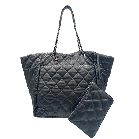 Front di una borsa tote Chanel Week End On Mars in pelle matelassé nera, con pochette interna e rifinita con parti metalliche argentate.