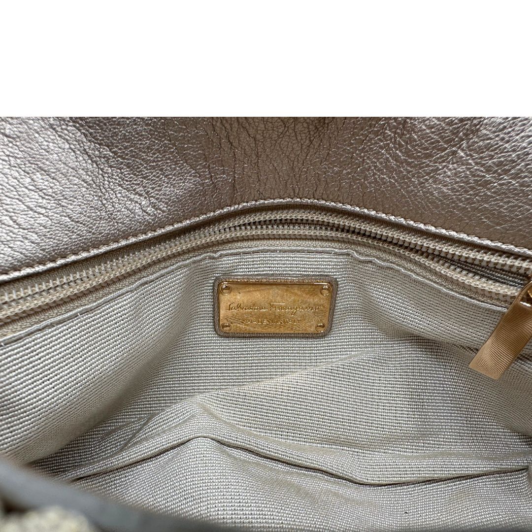 Interno di una borsa Salvatore Ferragamo in crochet con filato laminato. Dotata di manico corto in catena amovibile. Parti metalliche dorate, indossabile a spalla e a mano.