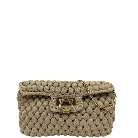 Front di una borsa Salvatore Ferragamo in crochet con filato laminato. Dotata di manico corto in catena amovibile. Parti metalliche dorate, indossabile a spalla e a mano.
