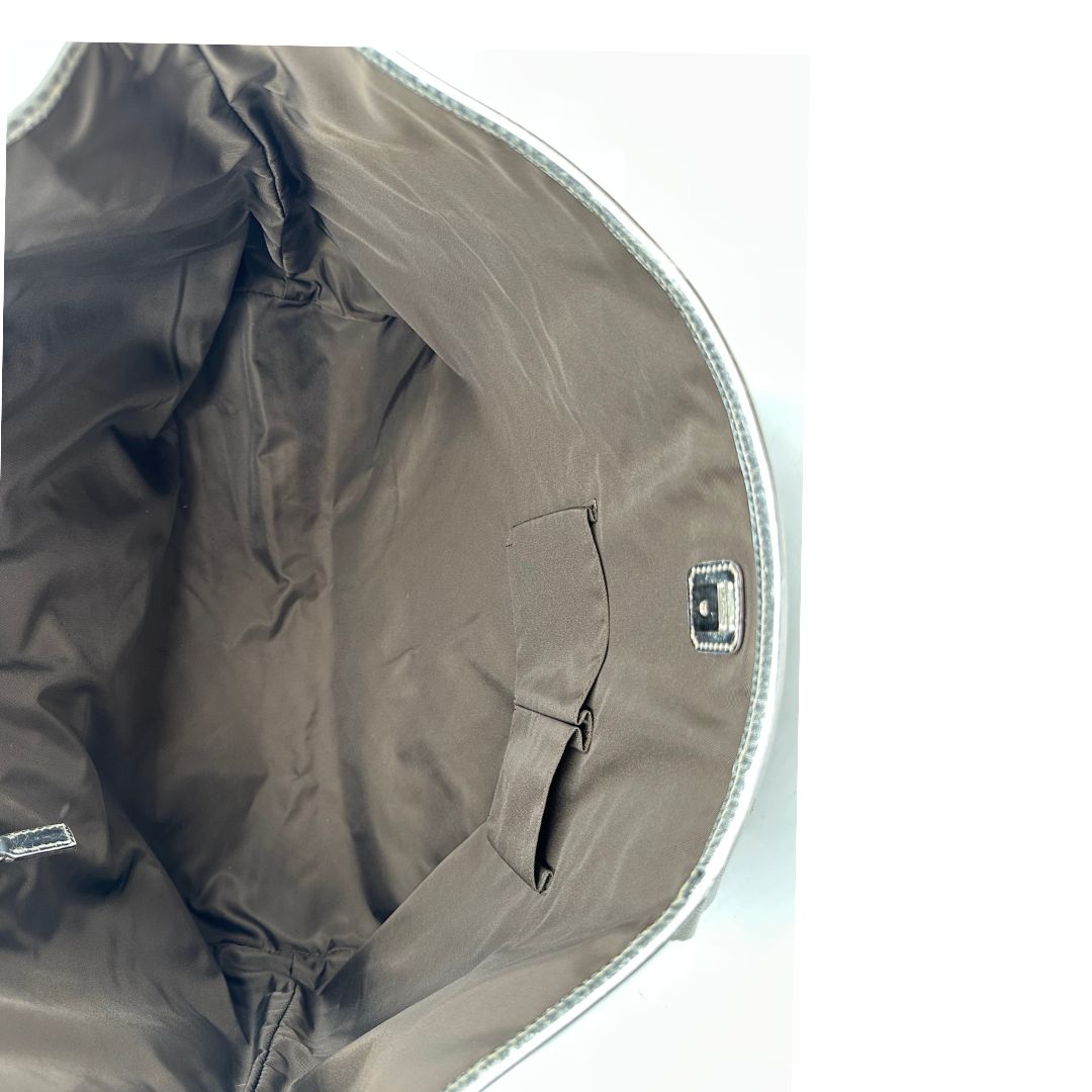 Interno Borsa Gucci in canvas grigio laminato GG con finiture in pelle Tono su tono e parti metalliche argentate. Dotata di Doppi manici e tracolla in tessuto regolabile.