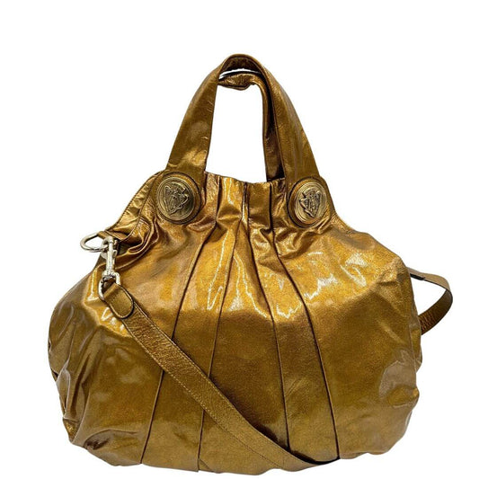 front Borsa Gucci in pelle lucida color oro bronzato rifinita con inserti metallici tono su tono; munita di doppi manici e una tracolla amovibile