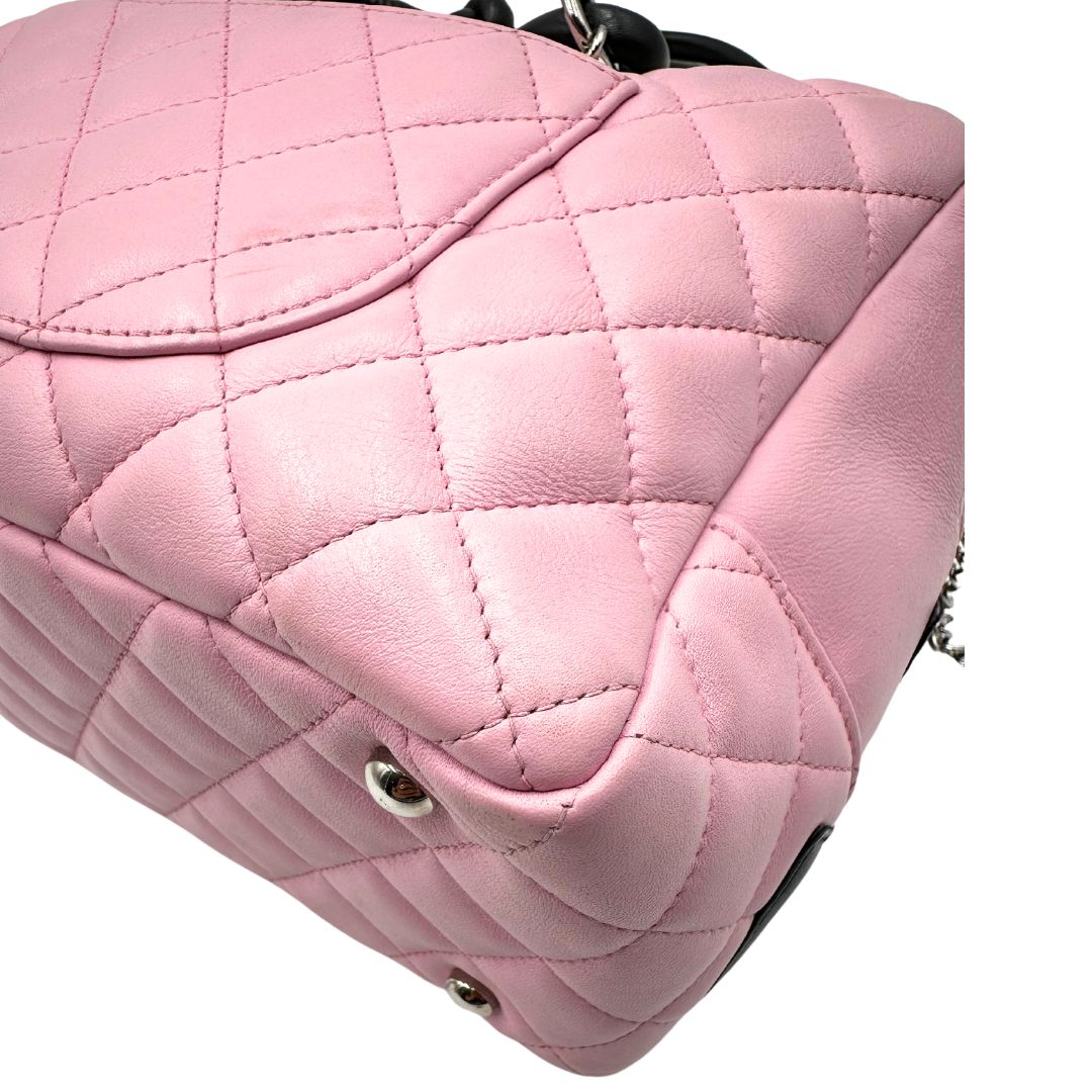 Angoli Borsa Chanel in pelle trapuntata rombi rosa con dettagli in pelle nera e parti metalliche argentate, rifinita con doppia CC in pelle sul front, munita di doppi manici in pelle e catena intrecciati, da portare a spalla.