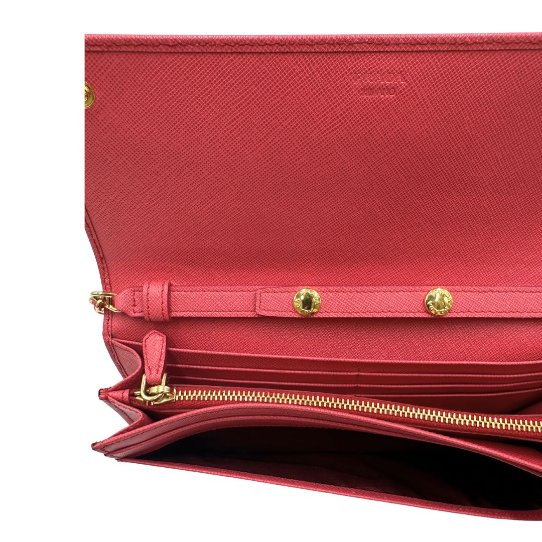 Interno Wallet On Chain Prada in pelle Saffiano rosa fragola con parti metalliche dorate. Munito di una tracolla amovibile in catena e pelle intrecciata. Completo di scatola. Originale, usato, in condizioni ottime.