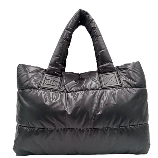 Front di una borsa Chanel in tessuto impermeabile matelassé nero, con metalleria argentata. Munita di dustbag e card d'autenticità. Da indossare a spalla.