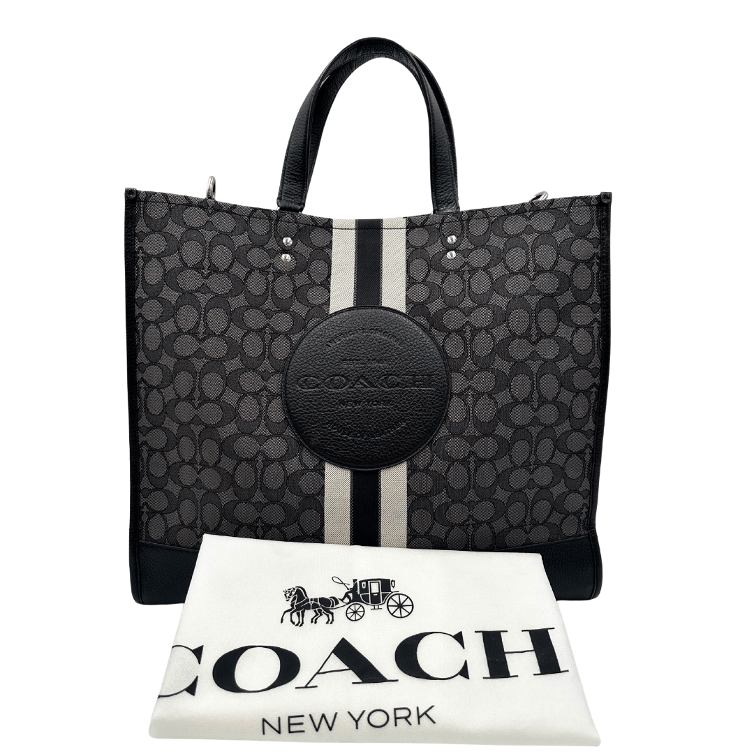 Sac Plat Coach in tessuto logato grigio con finiture in pelle martellata nera e parti metalliche argentate. Munita di doppi manici in pelle e una tracolla in tessuto regolabile, e amovibile. Completa di dustbag. Originale, usato, in condizioni ottime.