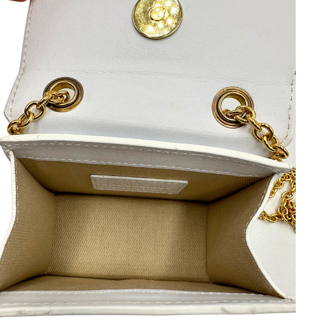 Interno Micro Chiquito Bag Jacquemus in pelle bianca con parti metalliche dorate, munita di una tracolla in catena. Completa di dustbag. Originale, usato, in condizioni ottime.