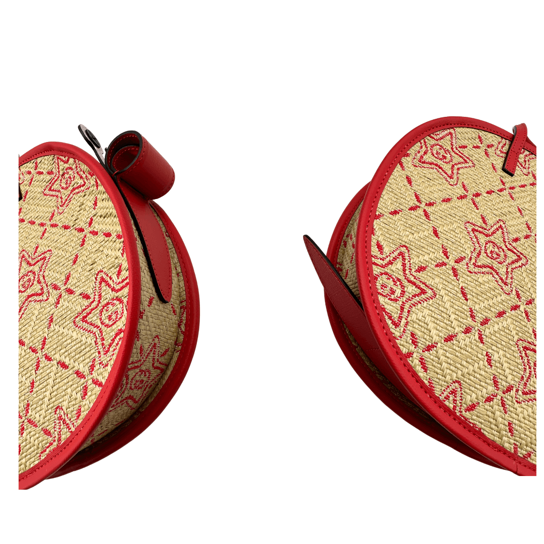 Angoli Borsa Gucci Bambina a forma di lumaca in rafia con trama GG e stampa decorativa con stelle. Finiture in pelle rossa e munita di doppi manici. Completo di cartellino. Originale, usato, in condizioni ottime.