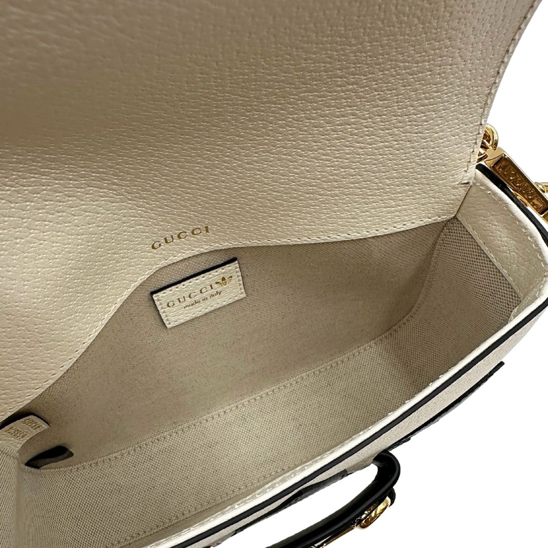 interno Borsa Gucci x Adidas in pelle martellata bianca con logo Adidas e parti metalliche dorate, munita di una tracolla Web verde e rossa. Completa di corredo, di lusso, originale.