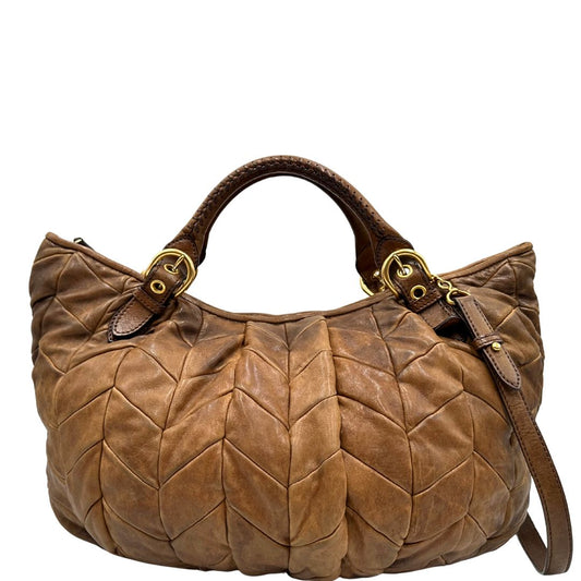 front Borsa Miu Miu in pelle color cammello con parti metalliche dorate; munita di un manico singolo e una tracolla amovibile, di lusso, usata, originale, ottime condizioni.