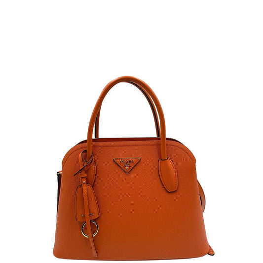 front Borsa Prada in pelle saffiano arancione con parti metalliche dorate; munita di doppi manici stondati e una tracolla amovibile e regolabile, impreziosita da una clochette portachiavi. Completa di corredo, di lusso, originale, ottime condizioni.