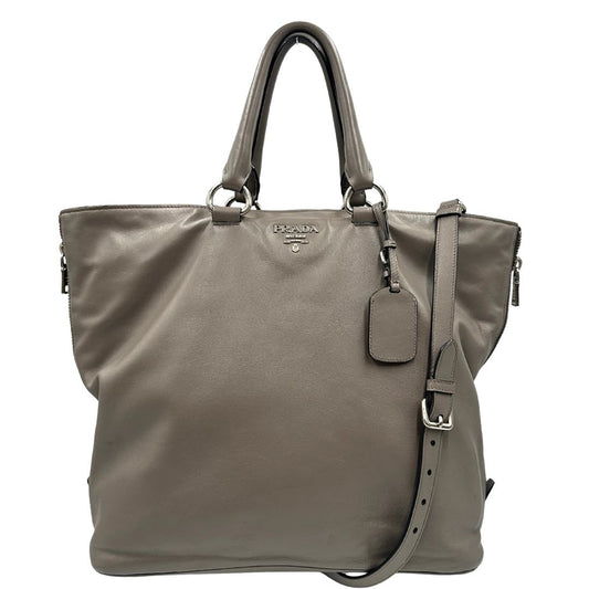 front Borsa Prada in pelle grigia con parti metalliche argentate; impreziosita da zip laterali e accessorio porta address, munita di doppi manici stondati e una tracolla amovibile e regolabile. Completa di dustbag, di lusso, originale, ottime condizioni.