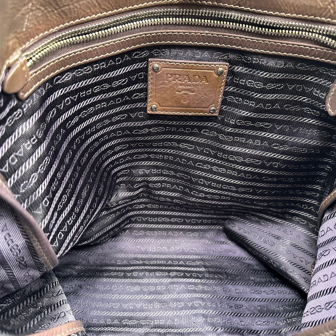 interno Borsa Prada in pelle lucida color cioccolato con parti metalliche argentate; munita di un accessorio porta address e doppi manici. Completa di dustbag, di lusso, originale, ottime condizioni.