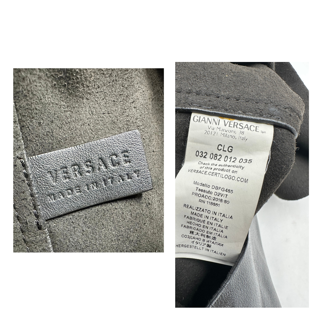 Shopper Versace in pelle nera con parti metalliche dorate munita di due manici con borchie dorate decorative. Indossabile a spalla. N.B. Pochette mancante e punto di aggancio in pelle tagliato dalla precedente cliente. Originale, usata, di lusso, in ottime condizioni.