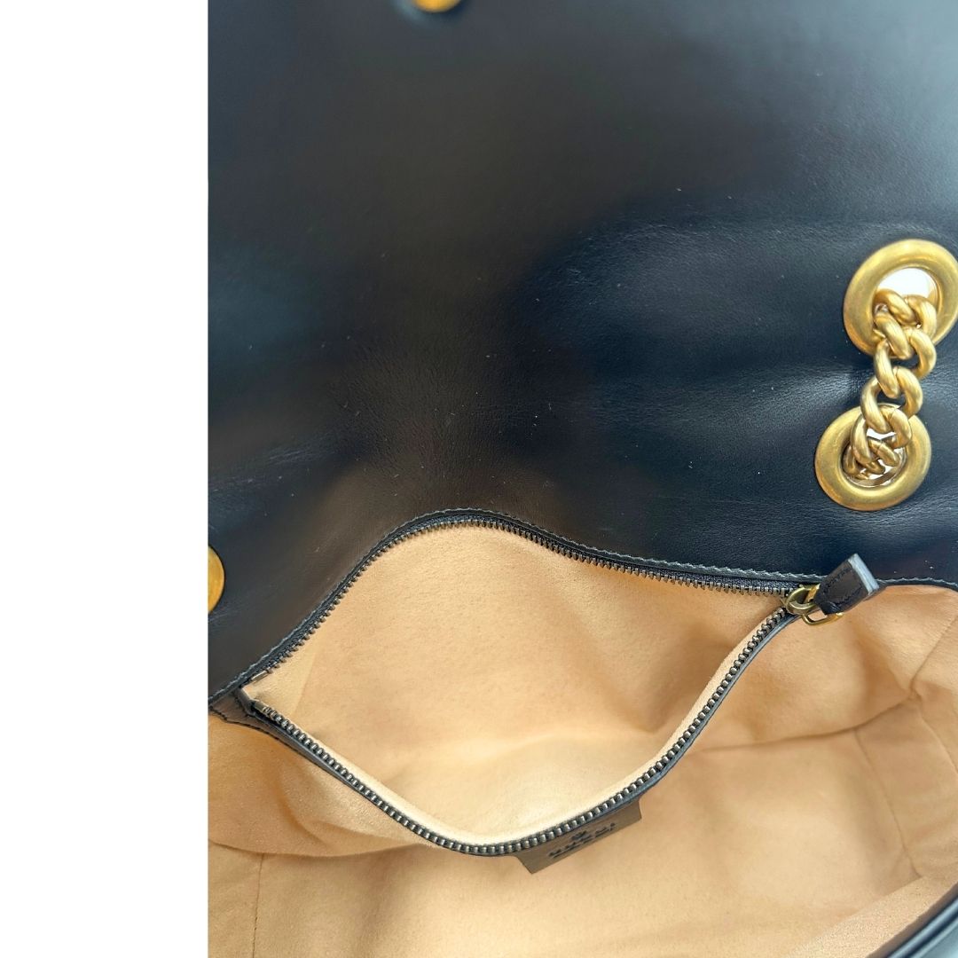 Interno di una Borsa Gucci Marmont in pelle matelassé nera con tracolla scorrevole in catena e spallaccio in pelle, rifinita con parti metalliche dorate; indossabile a spalla oppure a tracolla. Completa di dustbag. Originale, usata, di lusso, in ottime condizioni.