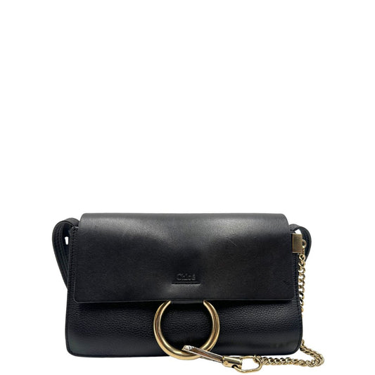 Front di una Borsa Chloé Faye in pelle martellata nera con parti metalliche dorate, munita di una tracolla regolabile. Impreziosita di una chiusura principale con gancio con l'iconico anello sul davanti, collegato a una piccola catena a moschettone. Indossabile a tracolla .Originale, usata, di lusso, in ottime condizioni.