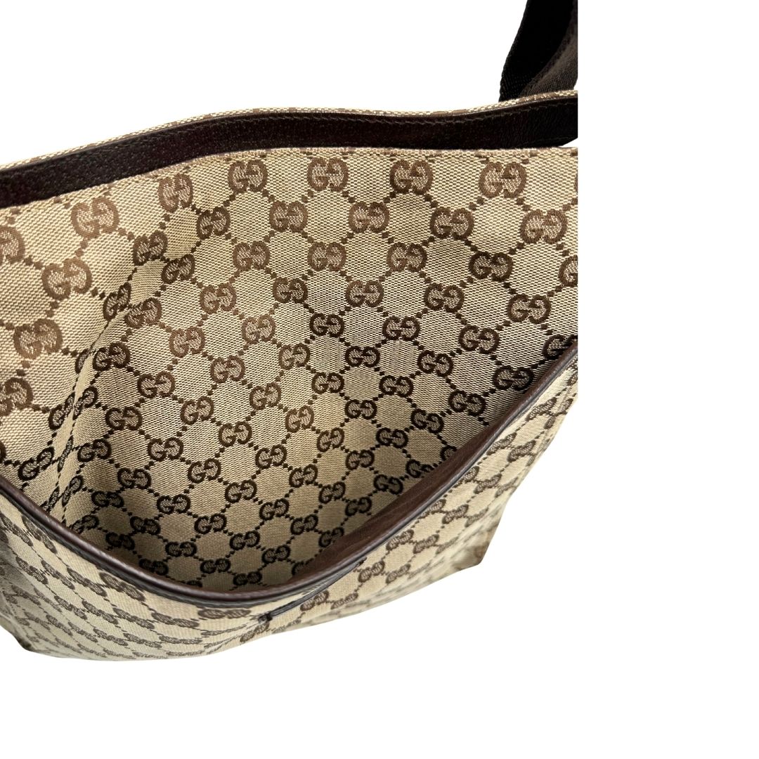 Tasca esterna di una Borsa Gucci in tessuto GG beige con finiture in pelle marroni, munita di una tracolla in tessuto regolabile. Indossabile a spalla. Originale, usata, di lusso, in ottime condizioni.