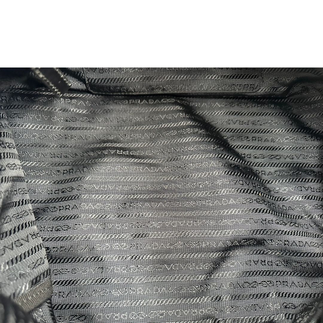 interno Borsa Prada in nylon con grafica decorativa e finiture in pelle nere e parti metalliche argentate; munita di doppi manici stondati e una tracolla amovibile e regolabile. Completa di corredo, di lusso, originale, ottime condizioni.