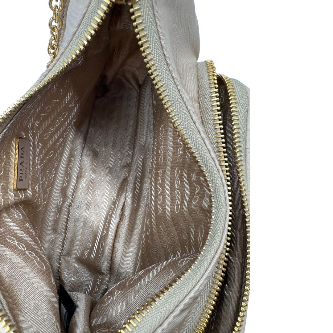interno Borsa Prada in nylon beige con finiture in pelle tono su tono con trama struzzo e parti metalliche dorate; munita di doppi manici, uno in catena e uno in pelle, entrambe amovibili, di lusso, originale, ottime condizioni.