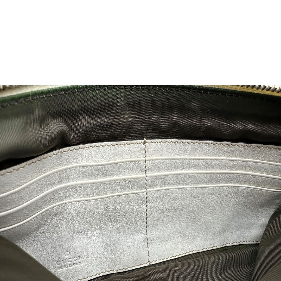 Interno di una Pochette Gucci in tessuto Gucci in tessuto GG beige con finiture in pelle bianca e parti metalliche dorate; munita di un polsino, da portare a mano. Completa di scatola. Originale, usata, di lusso, in ottime condizioni.