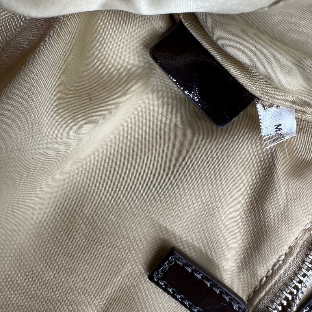 interno Pochette Moschino in ecopelle color testa di moro con parti metalliche argentate; munita di un polsino, da portare a mano. Completa di dustbag, di lusso, originale, ottime condizioni, usata.