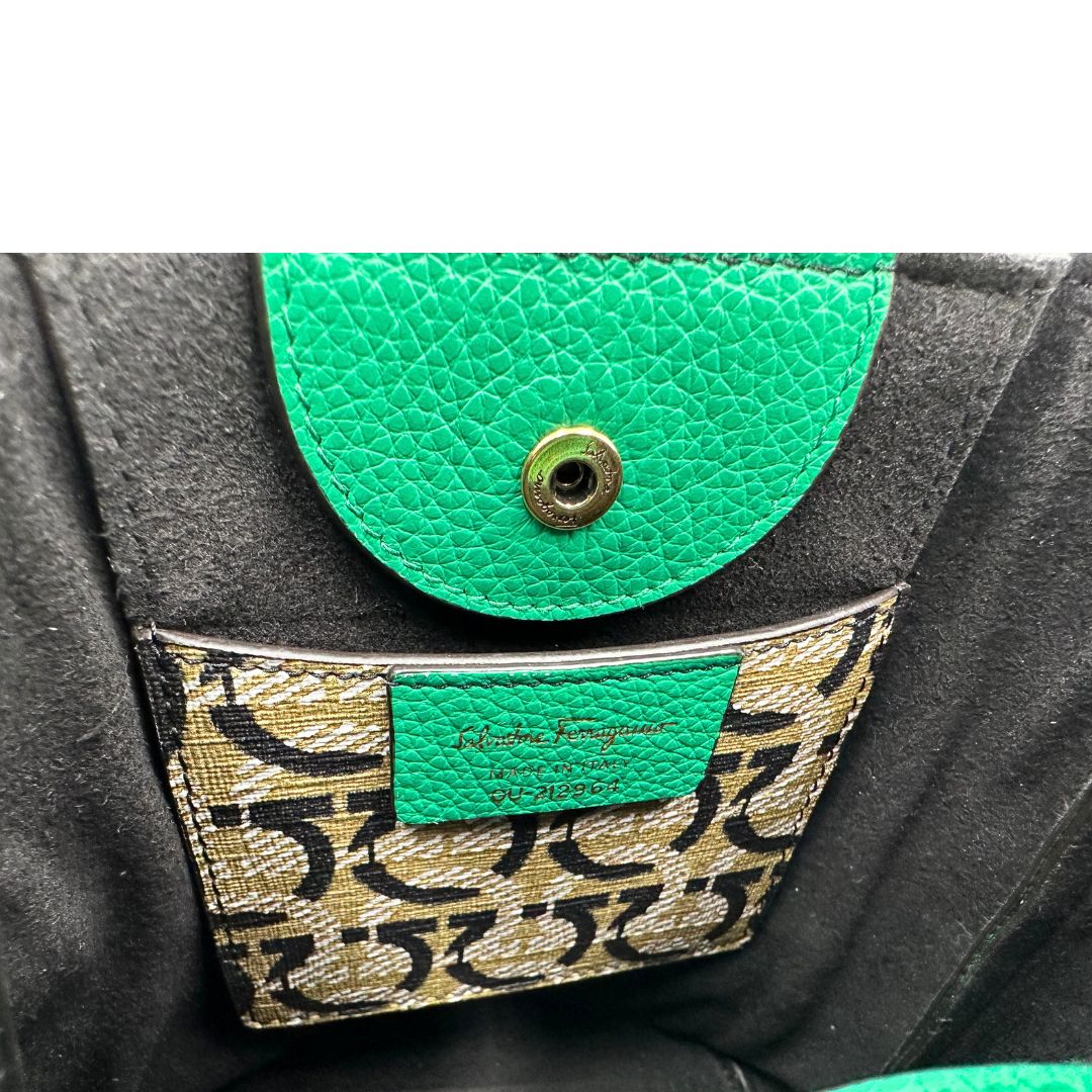 Interno, Borsa Salvatore Ferragamo in pelle martellata verde smeraldo, presenta l'iconico dettaglio a placca Gancini color oro sul davanti. Indossabile a mano o a tracolla. Originale, usata, di lusso, in condizioni eccellenti.