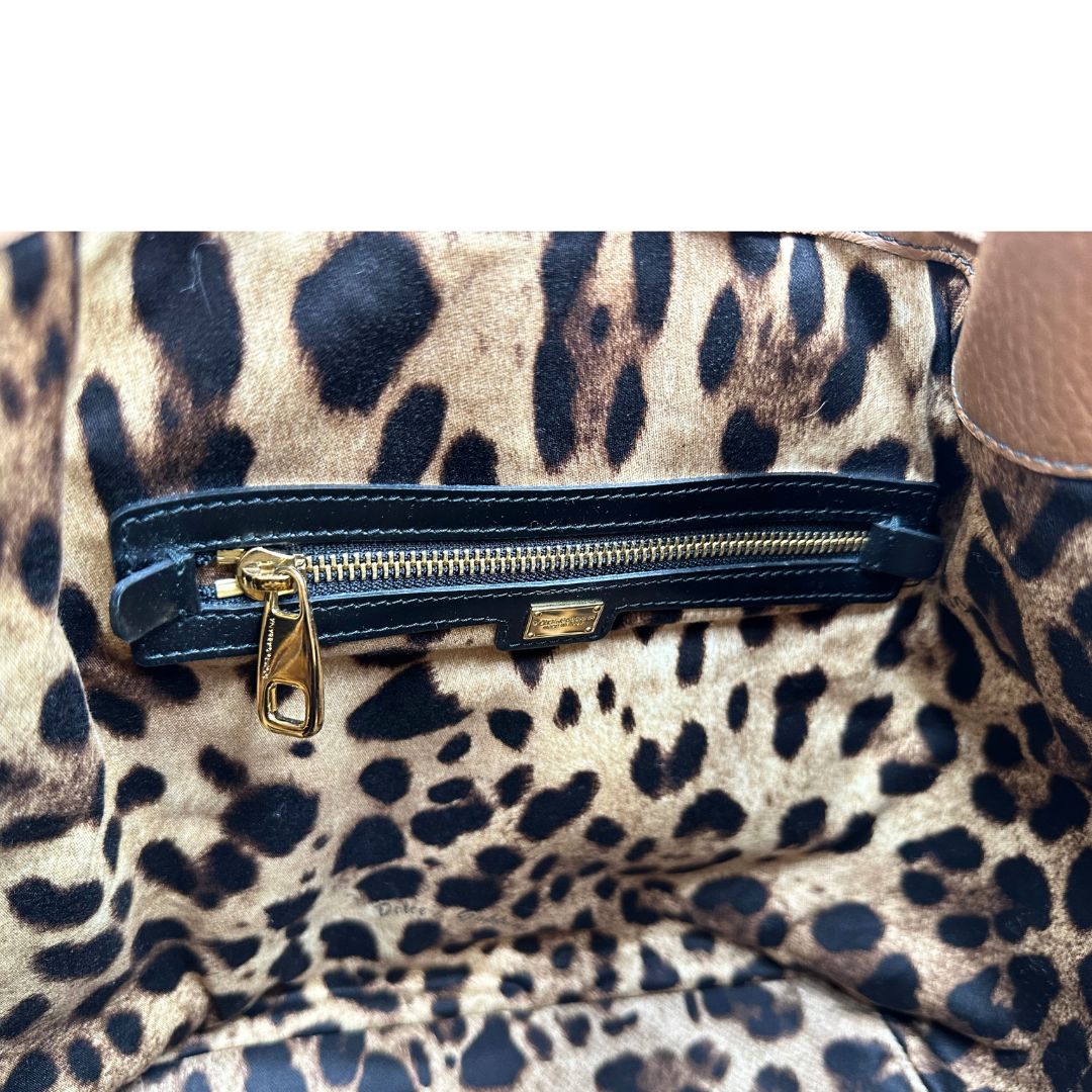 interno Borsa secchiello Dolce & Gabbana in pelle martellata color cuoio, dal design morbido e sofisticato. Il modello è caratterizzato da chiusura con coulisse, dettagli metallici color oro e silhouette strutturata ma versatile.