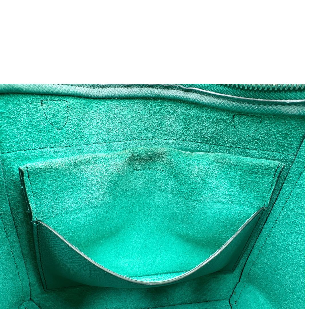 Elegante borsa Belt Bag di Celine, caratterizzata dall'iconico dettaglio a cintura sul davanti con nodi laterali e realizzata in pregiata pelle granulata verde smeraldo. Indossabile a mano oppure a tracolla. Originale, usata, di lusso, in ottime condizioni.