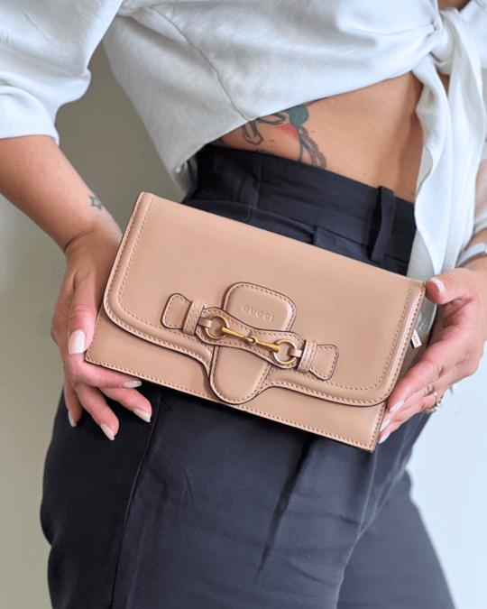 Portafoglio donna Gucci in pelle beige con dettaglio iconico Horsebit dorato, design elegante e compatto, ideale per outfit sofisticati e accessori di lusso.