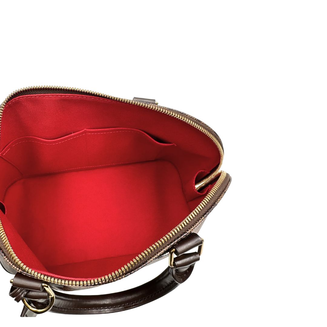 Interno, Strutturata borsa Alma PM LV in canvas Damier Ébène e hardware dorato, indossabile a mano oppure a tracolla.