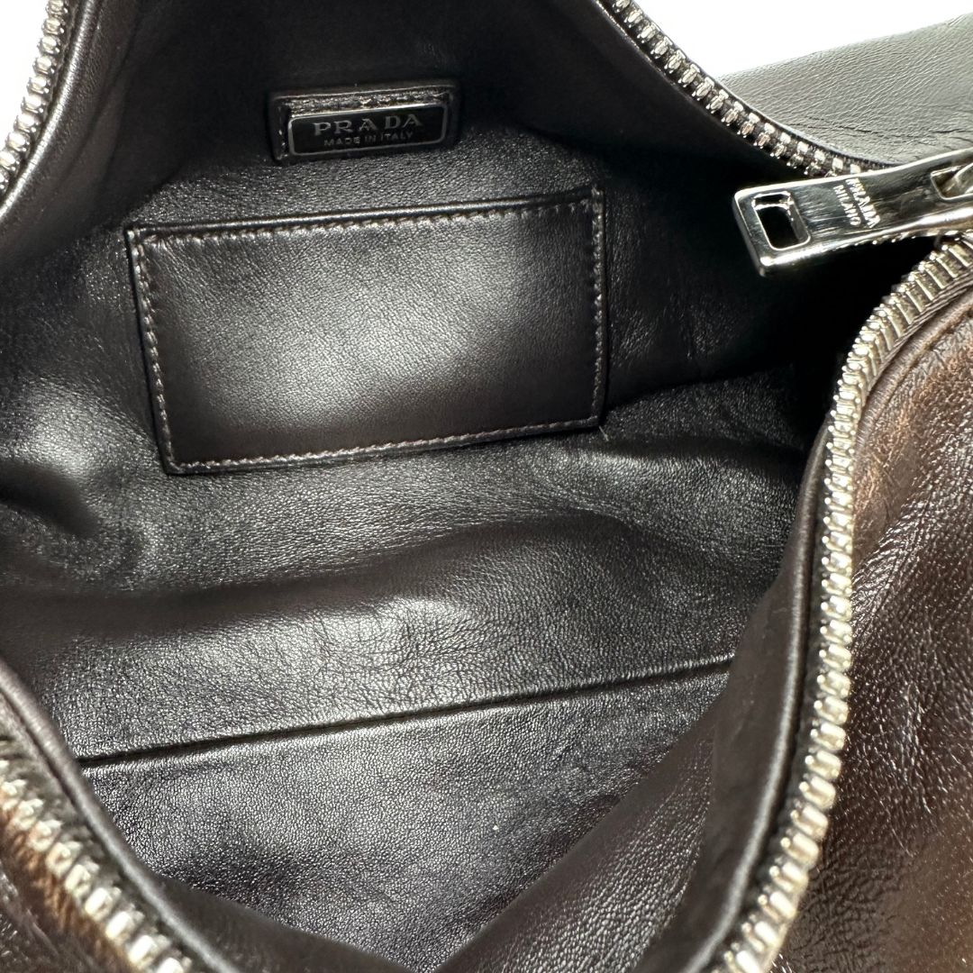 interno Borsa Prada in pelle marrone effetto distressed con parti metalliche argentate; munita di un manico singolo e una tracolla amovibile e regolabile. Completa di scatola, di lusso, originale, ottime condizioni. 