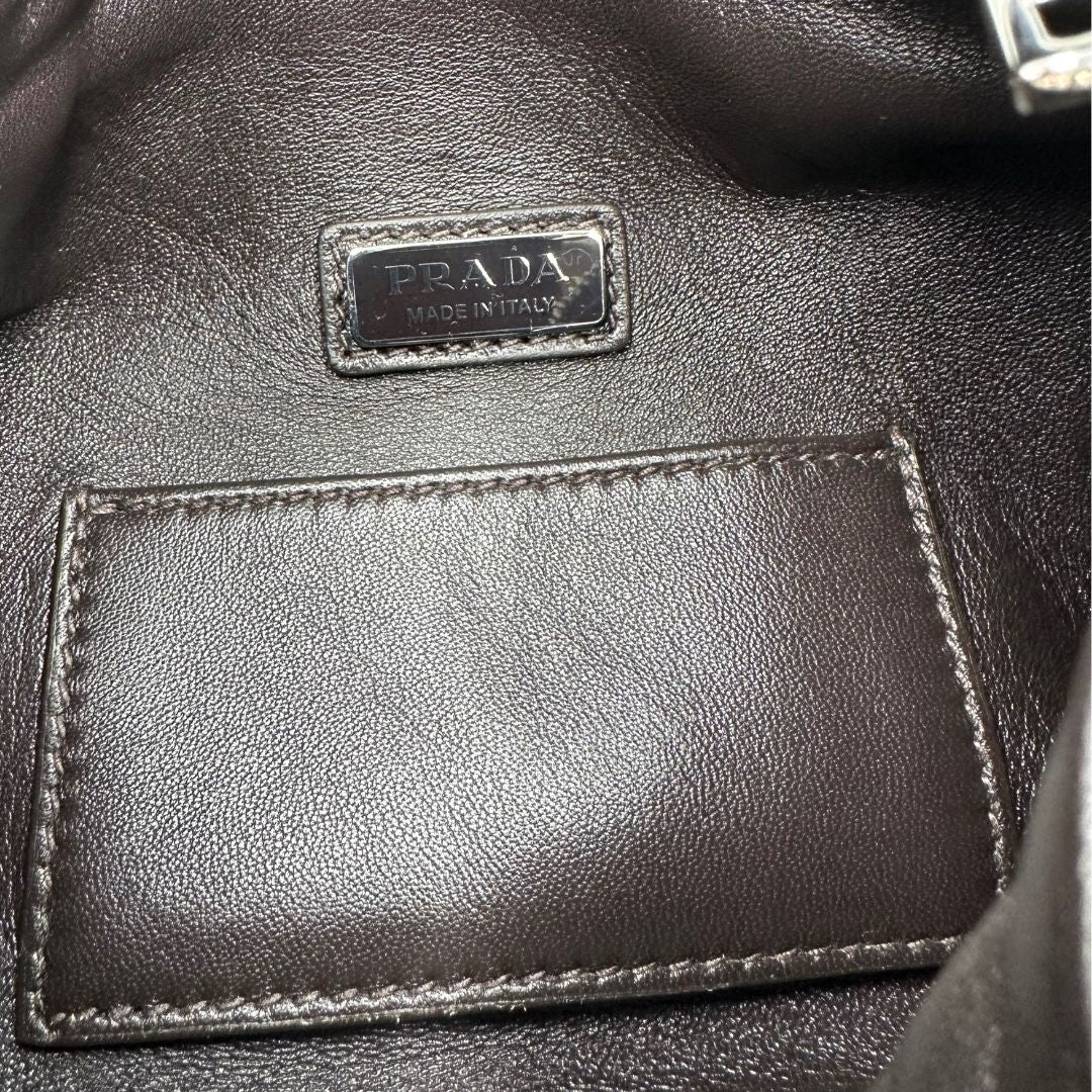 interno Borsa Prada in pelle marrone effetto distressed con parti metalliche argentate; munita di un manico singolo e una tracolla amovibile e regolabile. Completa di scatola, di lusso, originale, ottime condizioni. 
