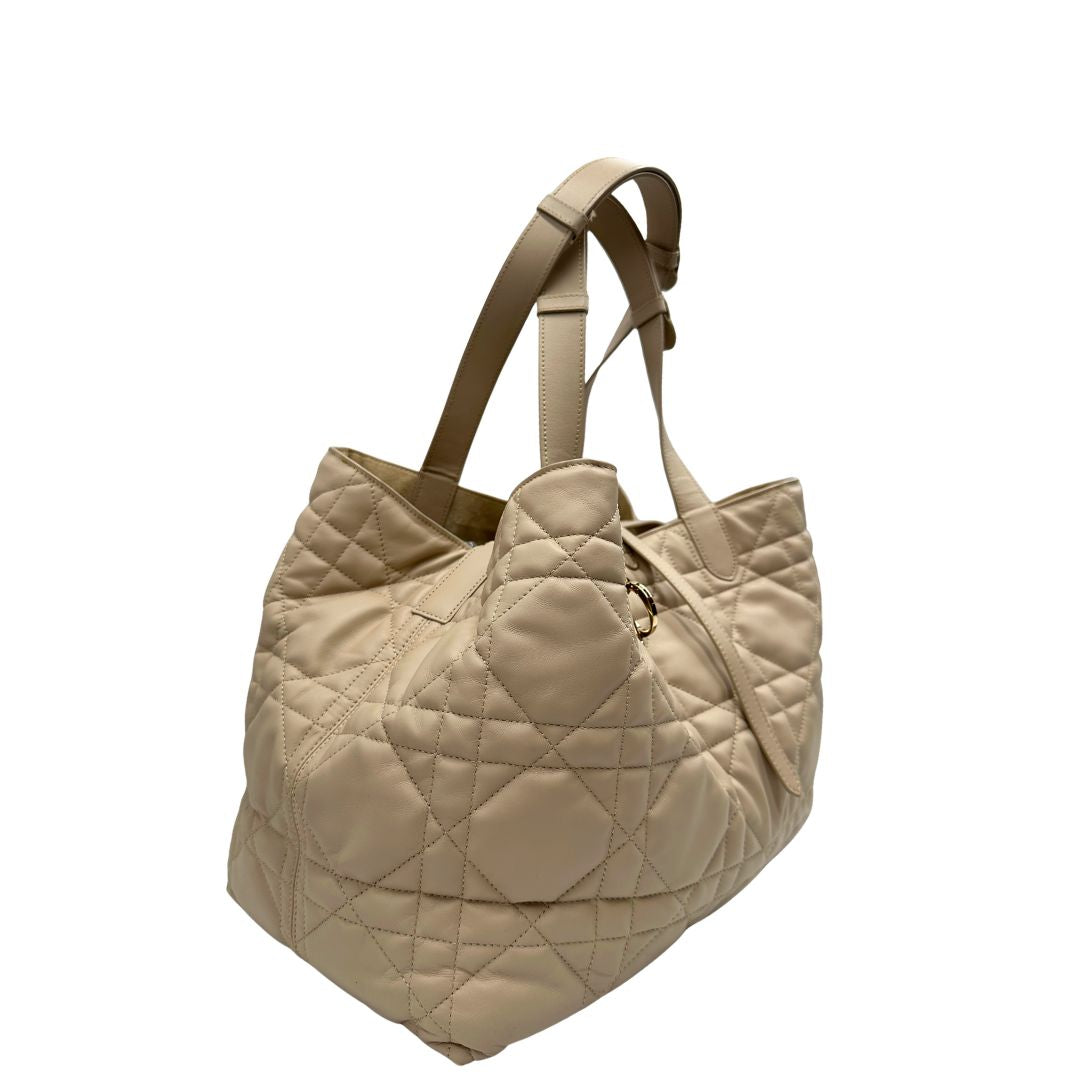 Lato destro, Borsa Christian Dior in pelle beige con impunture Macrocannage e parti metalliche dorate; munita di doppi manici regolabili e una pochette estraibile; da portare a mano o a spalla. Completa di dustbag, di lusso, originale, ottime condizioni. 