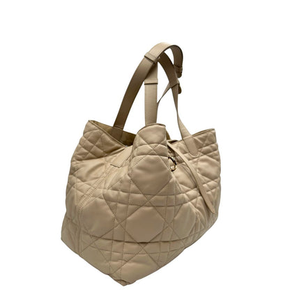 Lato destro, Borsa Christian Dior in pelle beige con impunture Macrocannage e parti metalliche dorate; munita di doppi manici regolabili e una pochette estraibile; da portare a mano o a spalla. Completa di dustbag, di lusso, originale, ottime condizioni. 