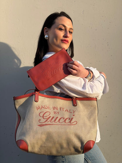 Ragazza che indossa una shopper Gucci Craft in tela beige, con finiture in pelle color rosa corallo. Dotata anche di una comoda pochette estraibile, usata, originale, second hand, in ottime condizioni.