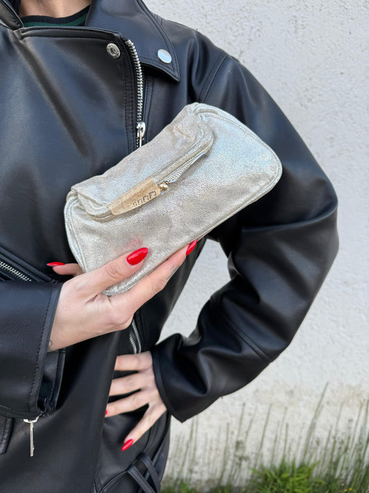 Ragazza che indossa una pochette Fendi argentata, indossabile a mano, usata, originale, second hand, in ottime condizioni.