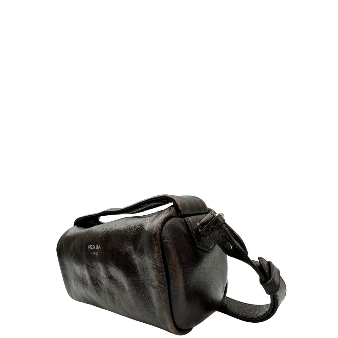 lato Borsa Prada in pelle marrone effetto distressed con parti metalliche argentate; munita di un manico singolo e una tracolla amovibile e regolabile. Completa di scatola, di lusso, originale, ottime condizioni. 