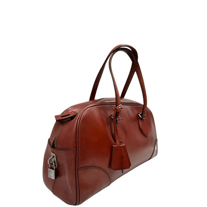 Borsa Prada in pelle color terracotta con parti metalliche argentate; munita di doppi manici. Completa di dustbag, lucchetto e chiavi, di lusso, originale, ottime condizioni.