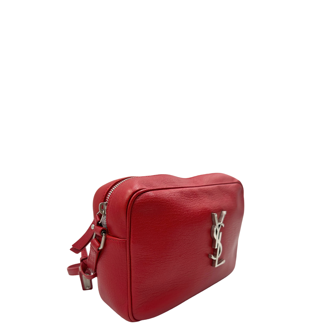 Laterale, Borsa Saint Laurent in pelle rossa con hardware argentato decorativo, iconiche iniziali YSL al centro e nappa decorativa. Indossabile a tracolla. Originale, usata, di lusso, in ottime condizioni.