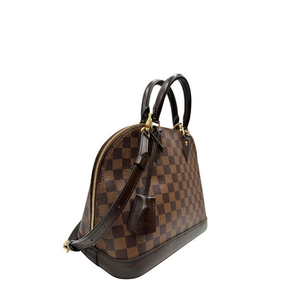 Lato destro, Strutturata borsa Alma PM LV in canvas Damier Ébène e hardware dorato, indossabile a mano oppure a tracolla.