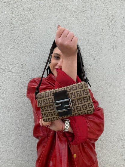 Ragazza che indossa una borsa mini Fendi Baguette beige e marrone in tessuto trama Zucchino, indossabile a spalla, usata, originale, second hand, in ottime condizioni.