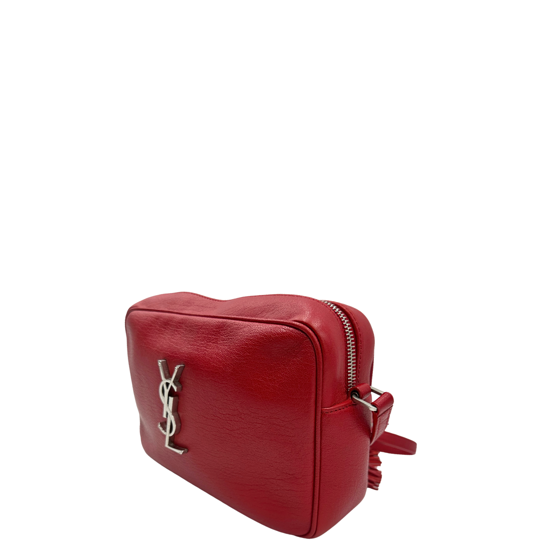 Laterale, Borsa Saint Laurent in pelle rossa con hardware argentato decorativo, iconiche iniziali YSL al centro e nappa decorativa. Indossabile a tracolla. Originale, usata, di lusso, in ottime condizioni.