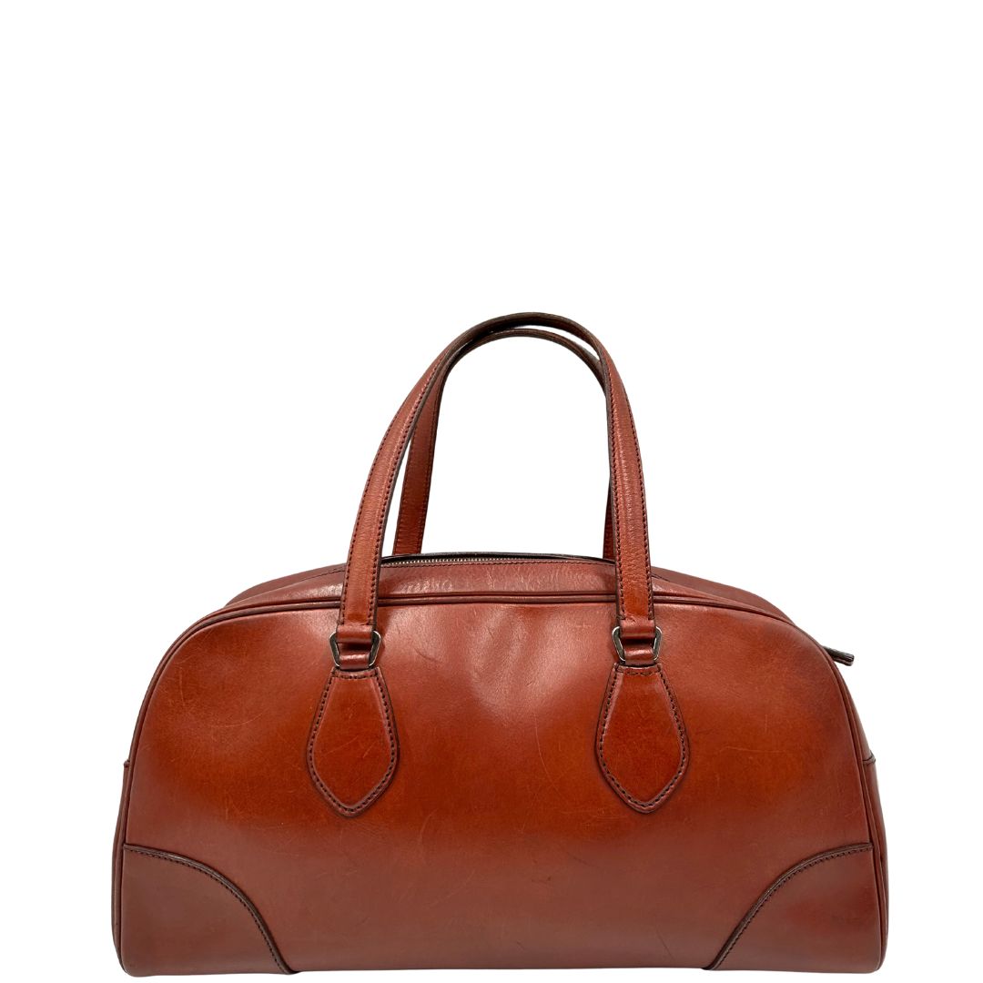 retro Borsa Prada in pelle color terracotta con parti metalliche argentate; munita di doppi manici. Completa di dustbag, lucchetto e chiavi, di lusso, originale, ottime condizioni. 