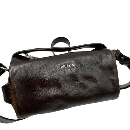Borsa Prada in pelle marrone effetto distressed con parti metalliche argentate; munita di un manico singolo e una tracolla amovibile e regolabile. Completa di scatola, di lusso, originale, ottime condizioni. 