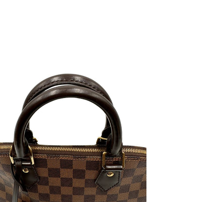 Manici, Strutturata borsa Alma PM LV in canvas Damier Ébène e hardware dorato, indossabile a mano oppure a tracolla.